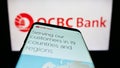 Mobile phone with webpage of Oversea-Chinese Banking Corporation (OCBC Bank) on screen in front of logo. Royalty Free Stock Photo