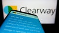 Mobile phone with webpage of US renewables company Clearway Energy Inc. on screen in front of business logo.