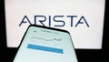 Mobile phone with website of computer networking company Arista Networks Inc. on screen in front of logo. Royalty Free Stock Photo