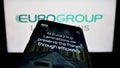 Mobile phone with website of Italian company EuroGroup Laminations S.p.A. on screen in front of business logo.