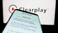 Mobile phone with website of parental control company Clearplay Inc. on screen in front of business logo.