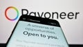 Mobile phone with website of payments company Payoneer Global Inc. on screen in front of logo.