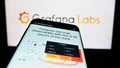 Mobile phone with website of US analytics software company Grafana Labs on screen in front of business logo.