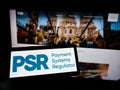Person holding cellphone with logo of British Payment Systems Regulator (PSR) on screen in front of business webpage. Royalty Free Stock Photo