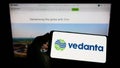 Person holding cellphone with logo of Indian mining company Vedanta Limited on screen in front of business webpage. Royalty Free Stock Photo