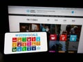 Person holding cellphone with logo of United Nations Sustainable Development Goals (SDG) on screen in front of webpage.