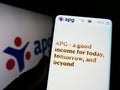 Person holding cellphone with webpage of pension fund Algemene Pensioen Groep (APG) on screen in front of logo.