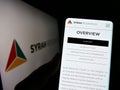 Person holding cellphone with website of Australian company Syrah Resources Limited on screen in front of logo.