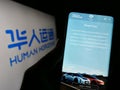 Person holding cellphone with website of Chinese company Human Horizons Technology on screen in front of logo.