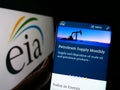 Person holding cellphone with website of US Energy Information Administration (EIA) on screen in front of logo.