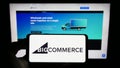 Person holding mobile phone with logo of American e-commerce company BigCommerce Inc. on screen in front of web page. Royalty Free Stock Photo