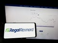 Person holding mobile phone with logo of American motor company Regal Rexnord Corporation on screen in front of web page.