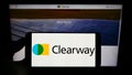 Person holding mobile phone with logo of American renewables company Clearway Energy Inc. on screen in front of web page.