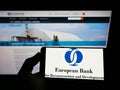 Person holding mobile phone with logo of European Bank for Reconstruction and Development (EBRD) on screen with webpage. Royalty Free Stock Photo