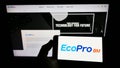 Person holding mobile phone with logo of South Korean company Ecopro BM Co. Ltd. on screen in front of business web page.