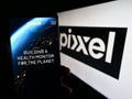 Person holding mobile phone with webpage of Indian company Pixxel Space Technologies Inc. on screen with logo.