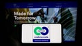 Person holding smartphone with logo of environmental label Cradle to Cradle Certified on screen in front of website.