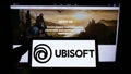 Person holding smartphone with logo of French video game company Ubisoft Entertainment SA on screen in front of website. Royalty Free Stock Photo