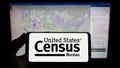 Person holding smartphone with logo of US agency United States Census Bureau (USCB) on screen in front of website. Royalty Free Stock Photo