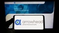 Person holding smartphone with logo of US company Arrowhead Pharmaceuticals Inc. on screen in front of website.