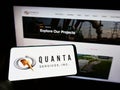 Person holding smartphone with logo of US infrastructure company Quanta Services Inc. on screen in front of website. Royalty Free Stock Photo