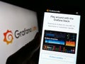Person holding smartphone with webpage of US analytics software company Grafana Labs on screen in front of logo.