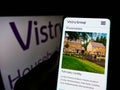 Person holding smartphone with website of British housebuilding company Vistry Group plc on screen with logo.