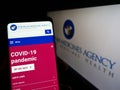 Person holding smartphone with website of EU agency European Medicines Agency (EMA) on screen in front of logo.