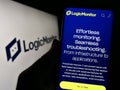 Person holding smartphone with website of US monitoring company LogicMonitor Inc. on screen in front of logo.