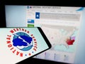 Smartphone with logo of American agency National Weather Service (NWS) on screen in front of website.