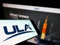 Smartphone with logo of American space company United Launch Alliance (ULA) on screen in front of website. Royalty Free Stock Photo