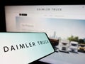 Smartphone with logo of automotive company Daimler Truck Holding AG on screen in front of business website.