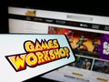 Smartphone with logo of British company Games Workshop Group plc on screen in front of business website.