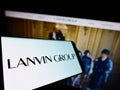 Smartphone with logo of Chinese fashion company Lanvin Group on screen in front of business website.