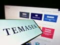 Smartphone with logo of company Temasek Holdings Private Limited on screen in front of business website.