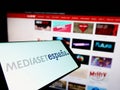 Smartphone with logo of Spanish media company Mediaset Espana on screen in front of business website.