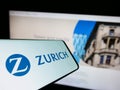 Smartphone with logo of Swiss financial company Zurich Insurance Group AG on screen in front of website.