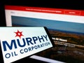 Smartphone with logo of US exploration company Murphy Oil Corporation on screen in front of business website.