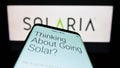 Smartphone with website of American solar panel company Solaria Corporation on screen in front of logo.