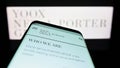 Smartphone with website of fashion company YOOX Net-a-Porter Group S.p.A. (YNAP) on screen in front of logo.