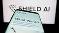 Smartphone with website of US aerospace and defense company Shield AI on screen in front of business logo.