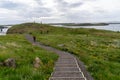 Stykkisholmur, Iceland - July 1, 2023: Hikers walk around Sugandisey Island and the lighthouse on walking trails