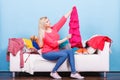 Woman looking through clothes on messy couch Royalty Free Stock Photo