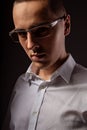 Style elegant young business man in eye glasses looking sreious and arrogant on dark shadow background. Closeup Royalty Free Stock Photo