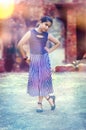 The style-fashionable Indian girl standing outdoor with hands on hips