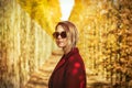 Girl in sunglasses and red coat in Versailles park Royalty Free Stock Photo