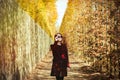 Girl in sunglasses and red coat in Versailles park Royalty Free Stock Photo
