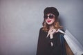 Style redhead girl in hat with shopping bags and sunglasses Royalty Free Stock Photo