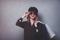 Style redhead girl in hat with shopping bags and sunglasses Royalty Free Stock Photo