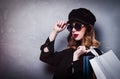 Style redhead girl in hat with shopping bags and sunglasses Royalty Free Stock Photo